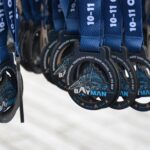 Médailles du Bayman 2026 prêtes à récompenser les athlètes franchissant la ligne d’arrivée du triathlon au pied du Mont-Saint-Michel.